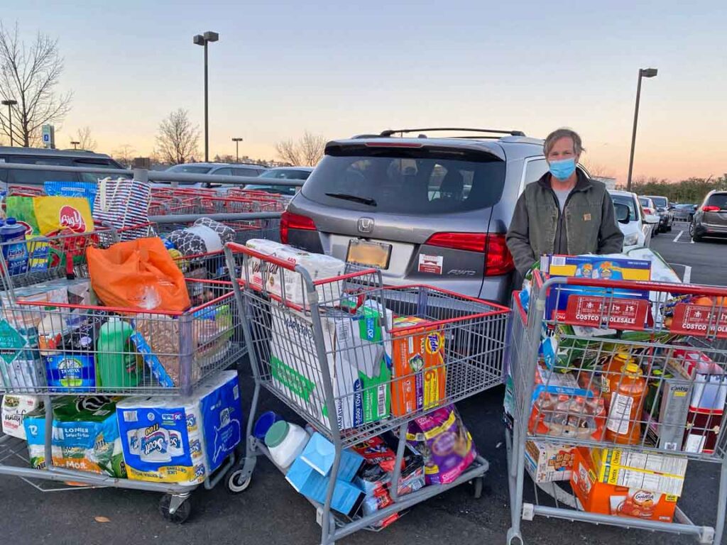 Bill Bradsell with shopping carts full of grocery donation items.