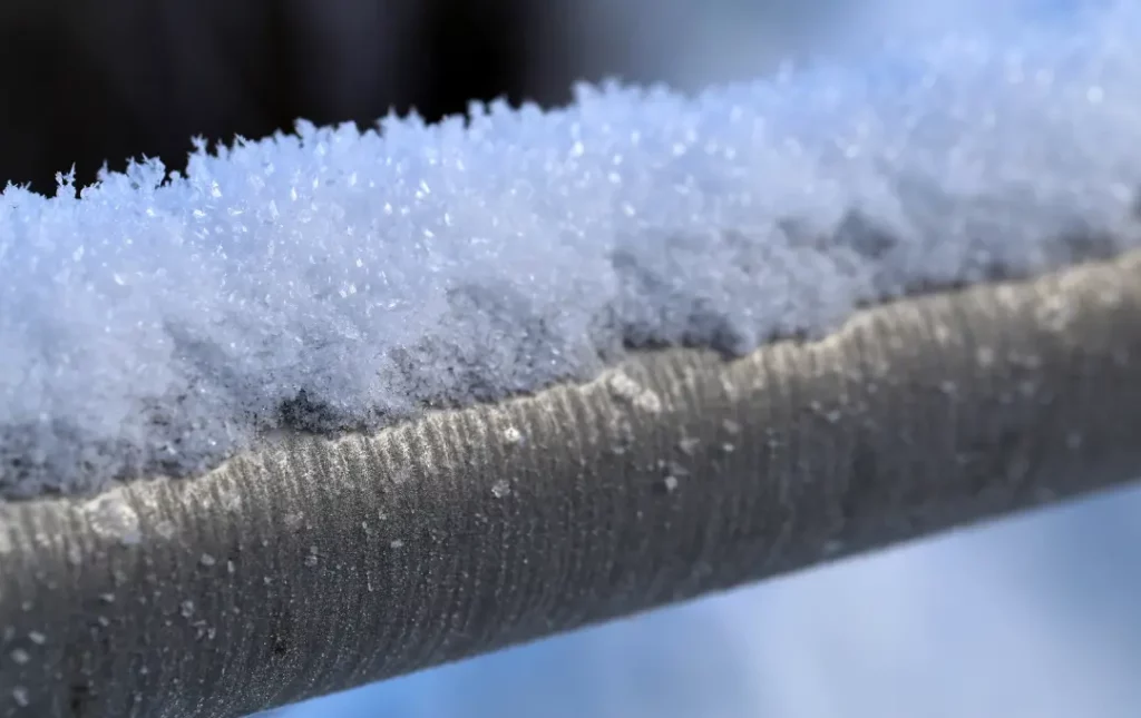 Snow on top of exposed outdoor pipe
